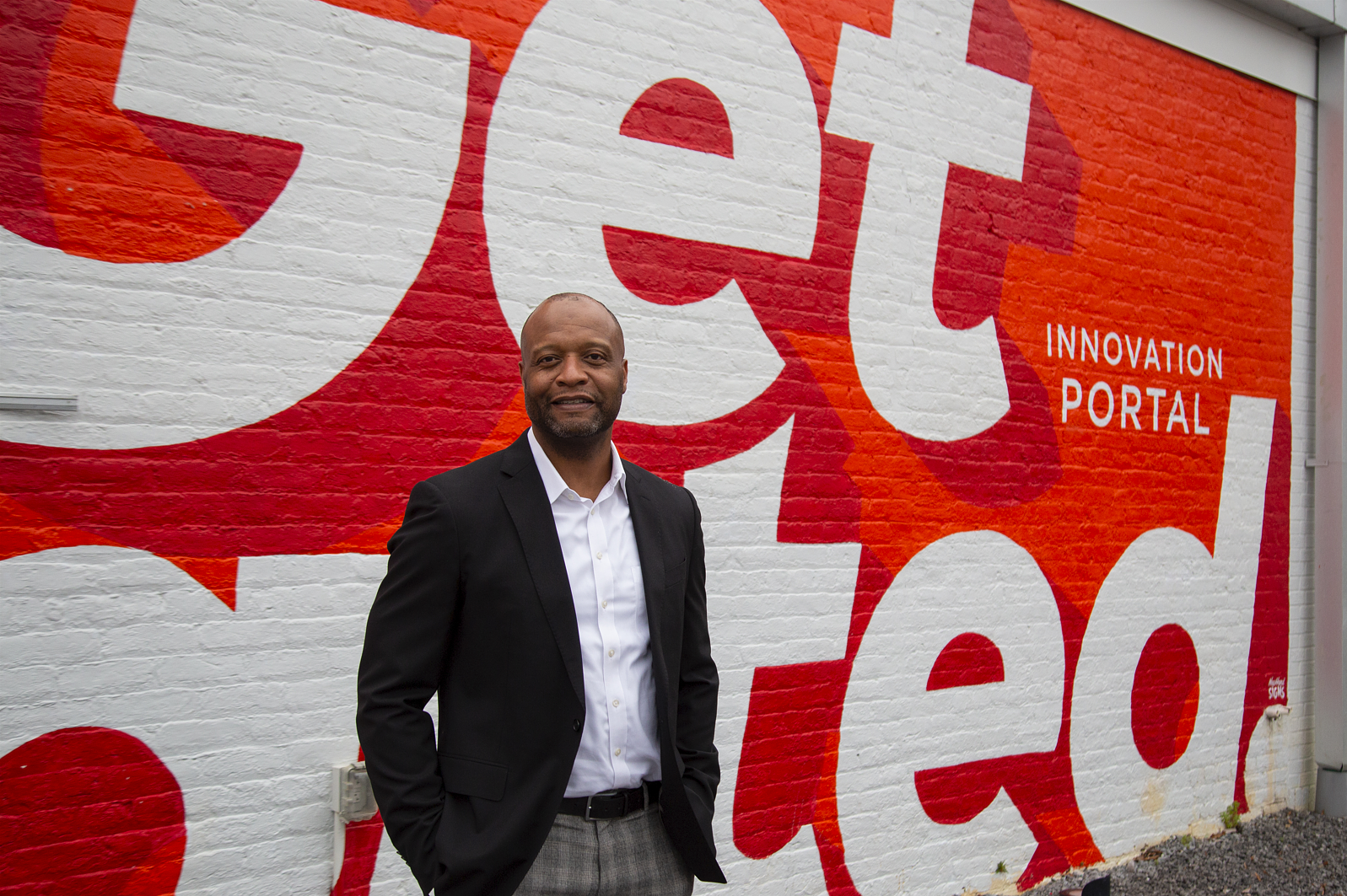 Image of Spire employee George Hunter standing in front of a mural that reads "Get started"