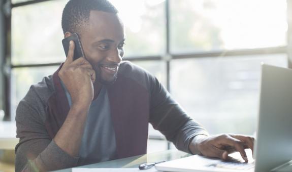 Man on the phone while using computer