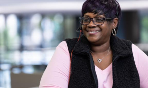Image of Spire employee wearing a pink shirt smiling at desk