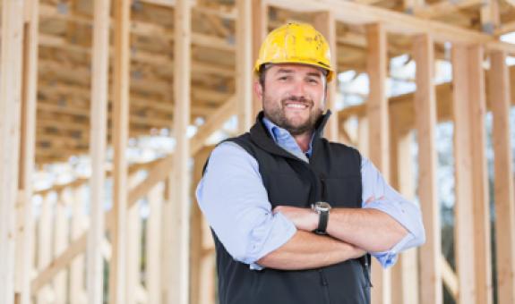 Image of contractor standing in front of wood at homebuilding