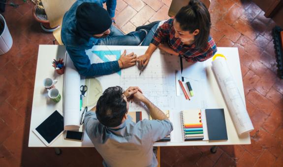 Image of builders collaborating with blueprints